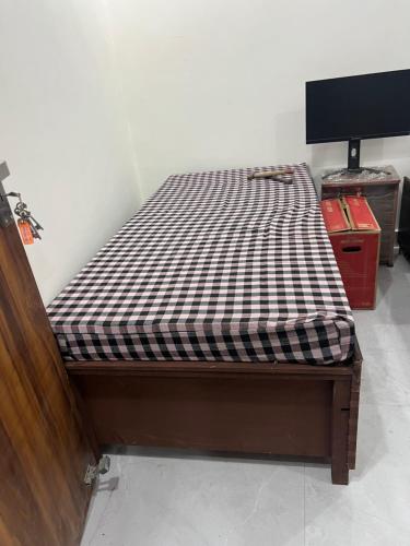 a bed with a black and white checkered mattress at Singhal PG-Rooms in New Delhi