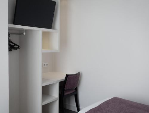 TV a/nebo společenská místnost v ubytování Brit Hotel de Grignan Vichy