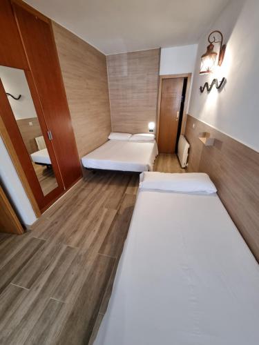 a small room with two beds and a mirror at Hotel Avanti in Pas de la Casa
