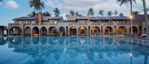a large swimming pool in front of a building at Le' VIVA Resort Mui Ne in Mui Ne