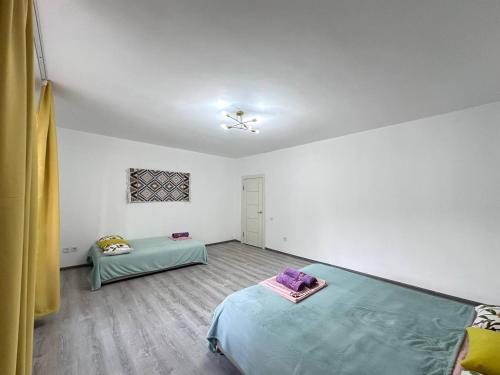 a bedroom with a bed and a table in it at Гавань Счастья in Almaty