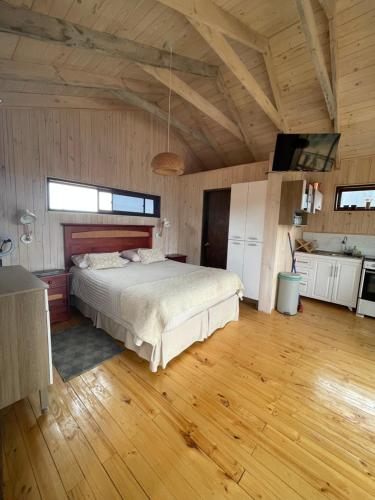 a large bedroom with a bed and a kitchen at Cabaña Pangal in Pichilemu