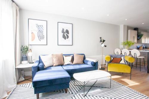 a living room with a blue couch and a table at Stylish and Modern 2 Bed House in Glasgow