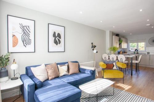a living room with a blue couch and a table at Stylish and Modern 2 Bed House in Glasgow