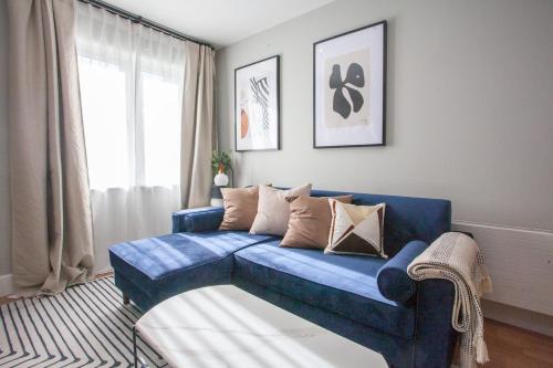 a blue couch in a living room with a window at Stylish and Modern 2 Bed House in Glasgow