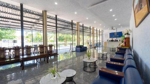 a lobby with blue chairs and tables and windows at Le' VIVA Resort Mui Ne in Mui Ne
