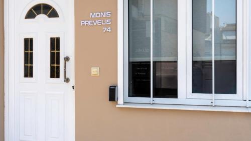 a white door and a window on a building at Heraklion Crete Monis Prevelis 74 3BRS 2BTHS Fast WiFi in Bendevís