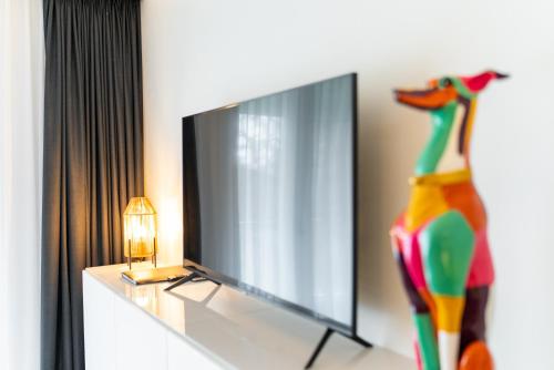 a flat screen tv sitting on top of a dresser at De Berkenhof Aparthotel in Nes