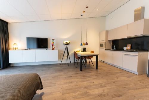 a room with a kitchen and a table in a room at De Berkenhof Aparthotel in Nes