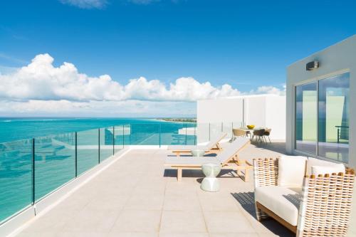a balcony with chairs and a view of the ocean at The Ritz-Carlton Residences, Turks & Caicos in Providenciales