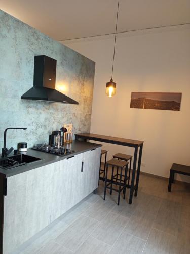 a kitchen with a stove and a counter with chairs at A CASA DI GIANNA in Napola