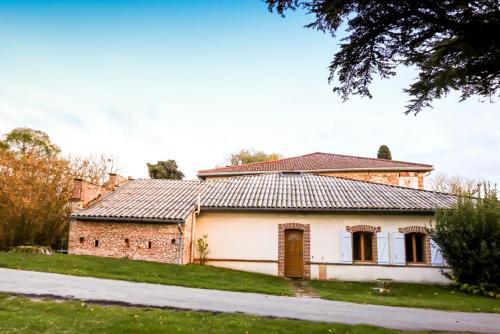 une vieille maison en briques avec un toit en tuiles dans l'établissement Métairie Roque-Basse, à Verfeil