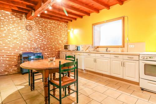 - une cuisine avec une table en bois et un évier dans l'établissement Métairie Roque-Basse, à Verfeil