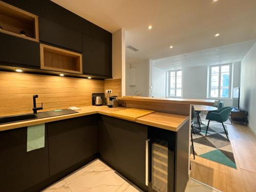 une cuisine avec des armoires noires et un comptoir dans l'établissement Appartements Centre Cannes, à Cannes