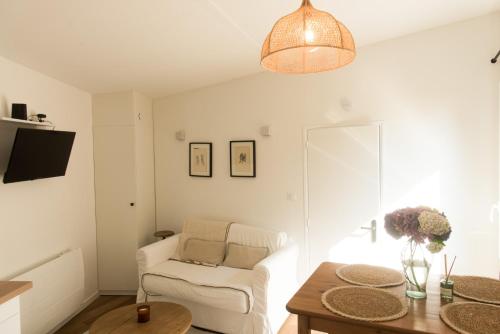 a living room with a white chair and a table at Le Cabanon Malouin in Saint Malo