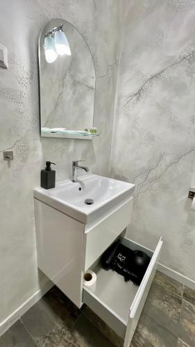 a white bathroom with a sink and a mirror at Hotel Fantazia Oradea - Self Check In & Out in Oradea