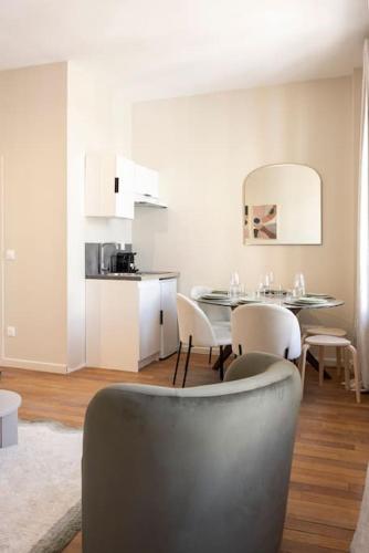 une salle à manger avec une table et des chaises et une cuisine dans l'établissement Appartement spacieux Proche 19ème arrondissement, à Le Pré-Saint-Gervais