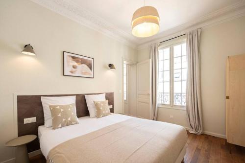 une chambre avec un grand lit blanc et une fenêtre dans l'établissement Appartement spacieux Proche 19ème arrondissement, à Le Pré-Saint-Gervais