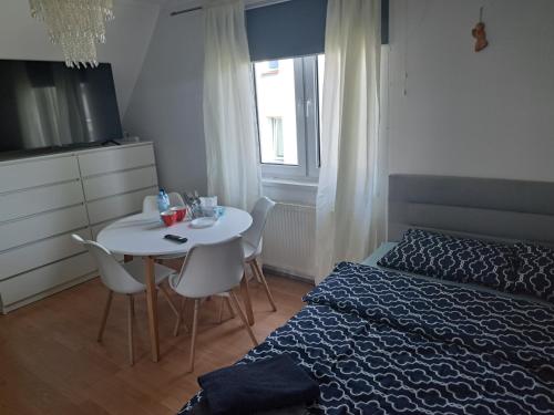 a bedroom with a bed and a table with chairs at APBapartamenty in Augustów