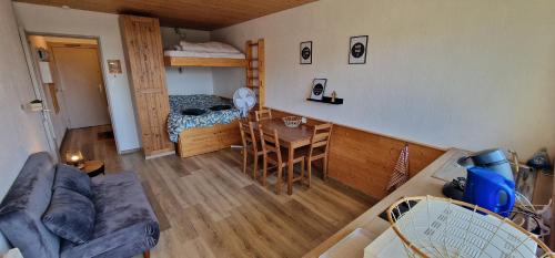 un salon avec un canapé, une table et un lit dans l'établissement Le Belle-Hutte, à La Bresse