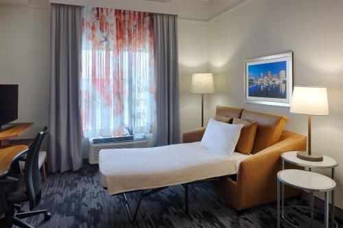 a hotel room with a couch and a desk at Fairfield Inn & Suites by Marriott Columbus Airport in Columbus