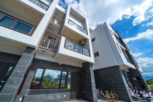 a large white house with bikes parked in front of it at Aidao B&B in Dazhou