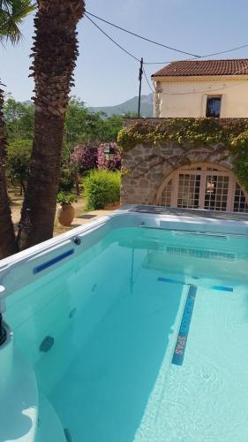 une grande piscine bleue devant une maison dans l'établissement Nouveautés 2025 du clos-La Tonnelle, à Calvi