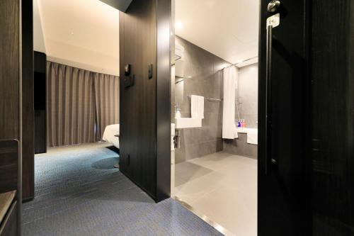 a bathroom with a door open to a bathroom with a sink at Richmond Hotel Premier Kyoto Shijo in Kyoto