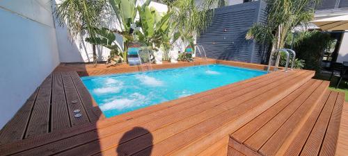 a swimming pool on a wooden deck with a wooden deck at La Maison della Valle in Agrigento