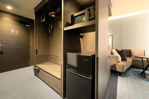 a kitchen with a refrigerator and a living room at Richmond Hotel Premier Kyoto Shijo in Kyoto