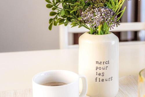a vase with flowers next to a cup of coffee at Italian Experience- Loreto Suite Apartment in Loreto