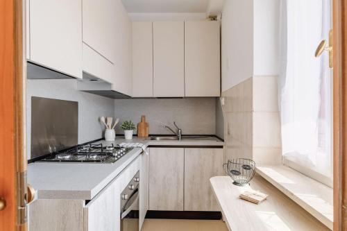 a kitchen with white cabinets and a stove top oven at Italian Experience- Loreto Suite Apartment in Loreto
