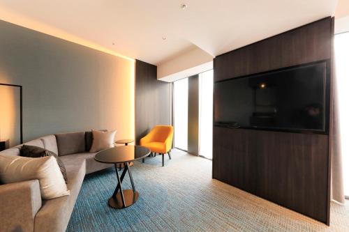 a living room with a couch and a tv at Richmond Hotel Premier Kyoto Shijo in Kyoto