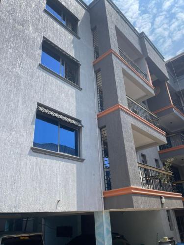 a building with two balconies on the side of it at Cozy Residence III 2bedroom Apartment near Speke Resort in Kampala