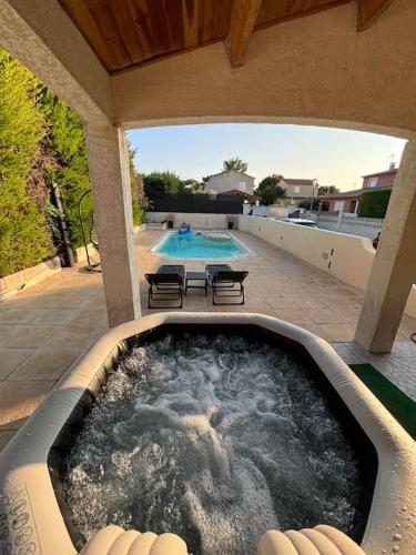 - un bain à remous sur une terrasse à côté d'une piscine dans l'établissement Villa avec piscine et Jacuzzi entre Aix et Marseille, à Gardanne