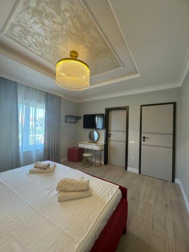 a bedroom with a large bed with a chandelier at The Cube in Sibiu