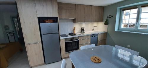 une petite cuisine avec une table et un réfrigérateur dans l'établissement L'Enclos des Lys STUDIO, à Aurillac