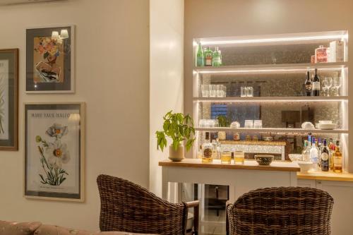 a bar with two chairs and a counter at ELIVAAS 4 BHK with Pvt pool & Bar - PinkSky in Arpora