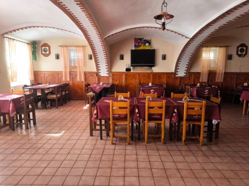 Un restaurante con mesas y sillas y un televisor de pantalla plana. en Penzion U Zeleného Stromu, en Telnice