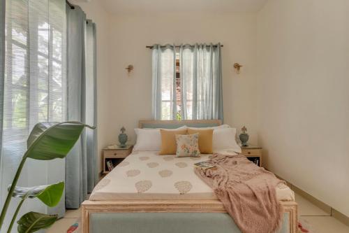 a bedroom with a bed with a blanket on it at ELIVAAS 4 BHK with Pvt pool & Bar - PinkSky in Arpora