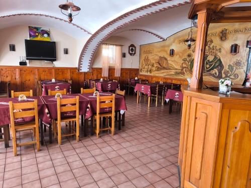Un restaurante con mesas y sillas y un televisor de pantalla plana. en Penzion U Zeleného Stromu, en Telnice