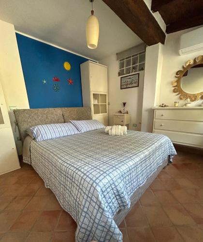 a bedroom with a bed with a blue wall at Casa Vacanze Eloise in Quartu SantʼElena