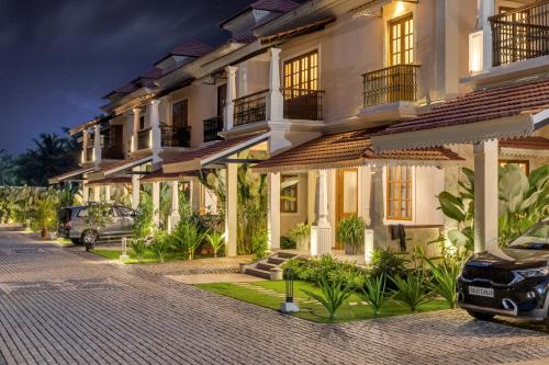 a building with a car parked in front of it at ELIVAAS 4 BHK with Pvt pool & Bar - PinkSky in Arpora