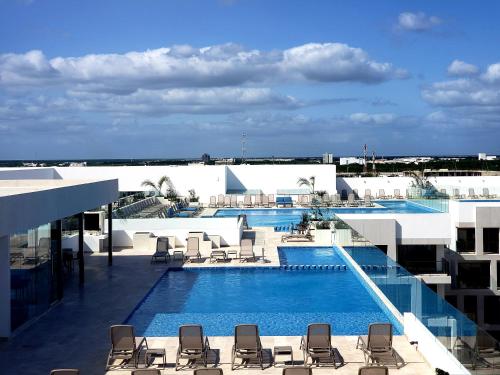 a swimming pool with lounge chairs on a building at Stylish Luxury Condo in the heart of Playa in Playa del Carmen