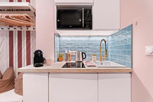 une cuisine avec un évier et un micro-ondes dans l'établissement Nice Renting - SPITALIERI - Chic & Cosy Art Deco Nest Nice Étoile, à Nice