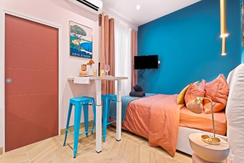 - une chambre avec des murs bleus et un lit avec des tabourets dans l'établissement Nice Renting - SPITALIERI - Chic & Cosy Art Deco Nest Nice Étoile, à Nice