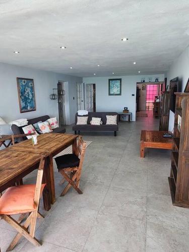 a living room with a wooden table and a couch at Casa Rosa 2 bedroom beach fronted home with private pool in Chelem