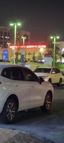 a white car parked on a city street at night at MAMA DELiGHT HOME in Abu Dhabi