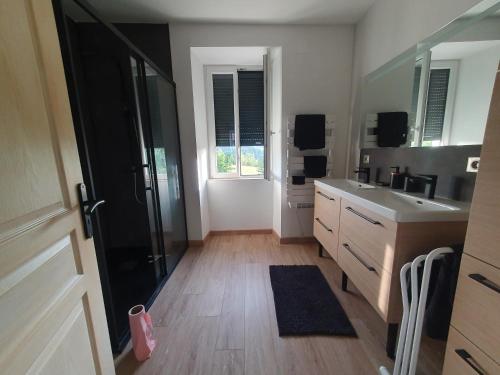 une grande cuisine avec un évier et un miroir dans l'établissement Maison dans ancien corps de ferme 4 à 6 personnes, à Saint-Clément