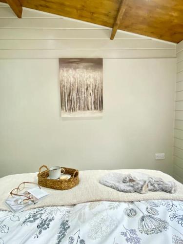 a bed with a basket and a picture on the wall at Mill Farm Retreat in Gortin